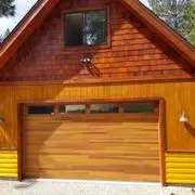 The horizontal wood planks on this garage door are stained the same color as the wood on the house.