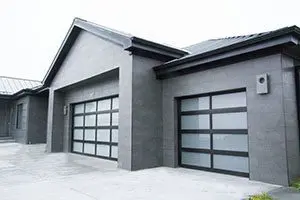The linear design over the shiny gray of the three car garage doors is very modern